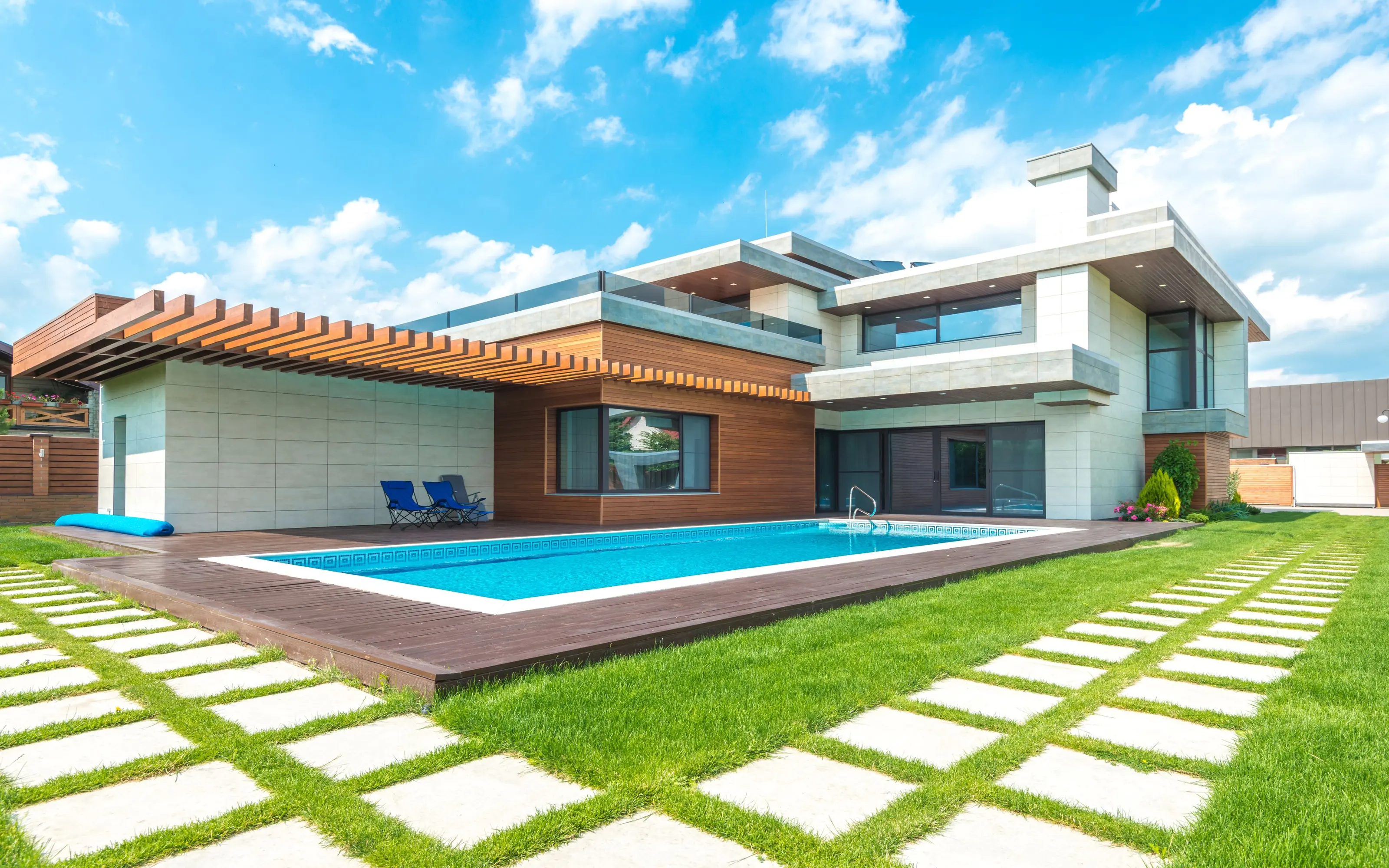 Contemporary residence with floor-to-ceiling windows, a landscaped lawn and a swimming pool